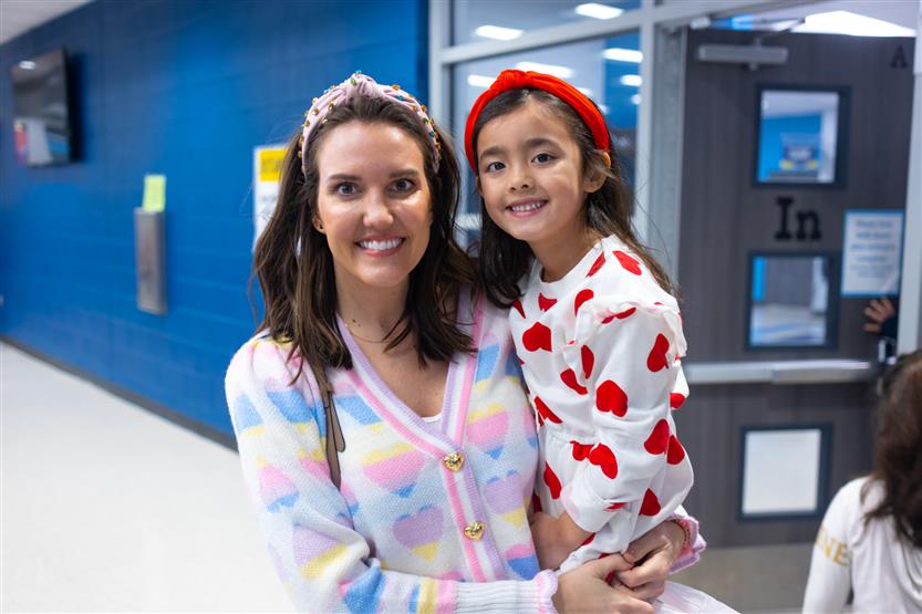 Creekside Elementary students eat donuts with a grown-up